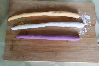 取一小个揉好的紫薯面团，揉搓成长条，切成长1.5厘米，红薯面团、香芋面团也用相同方法。