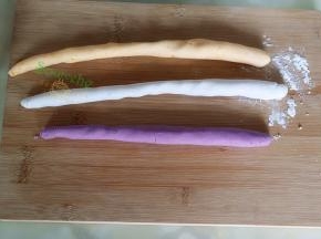 取一小个揉好的紫薯面团，揉搓成长条，切成长1.5厘米，红薯面团、香芋面团也用相同方法。
