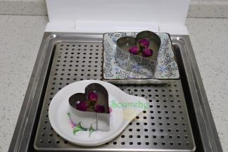 蒸至3分钟的时候，即凝固状态，放入洗净的玫瑰花，然后玫瑰花上面倒倒满水晶糕浆糊，继续蒸熟，
