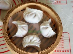 水晶虾饺是半月形，蝴蝶肚共有十二褶，这是粤式经典的水晶虾饺做法。做好的饺子，放入竹编蒸笼。