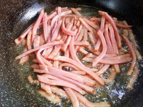 油热后放入火腿丝煸炒出香味。