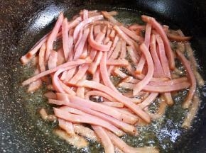 油热后放入火腿丝煸炒出香味。