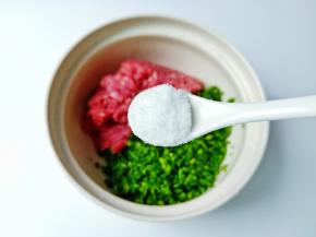将猪肉与韭菜末放容器，加盐半勺。