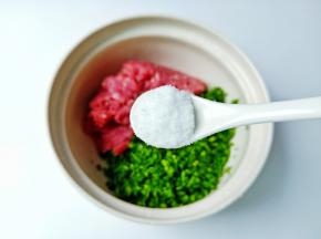将猪肉与韭菜末放容器，加盐半勺。