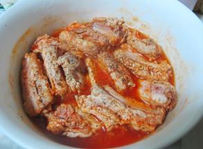 将排骨放入一个瓷的或者玻璃的大容器中，  加入调好的烤肉料，  注意一定要让排骨充分浸泡在烤肉料里，  再撒上现磨的黑胡椒细粒，  如果烤肉料不够多，  不能完全浸泡排骨，  就按照比例再调一些加入。  图中是已经腌制了24小时左右的样子。