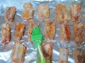 用刷子蘸一些烤肉料，  刷在排骨上，  再刷一层食用油，  如果有烧烤专用油就更好了。  烤箱预热好，  就可以将排骨放入烤了