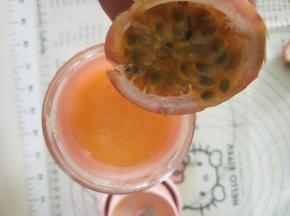 7、将百香果果肉挖出放在果汁中搅拌均匀即可饮用了。