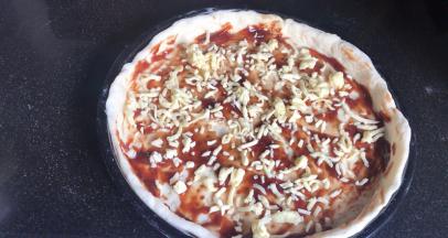 抹上披萨酱，撒上一层马苏里拉芝士