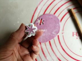 紫色小面团用擀面棍擀成薄面皮，用花型模具压出8朵小花