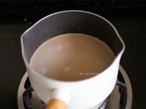接下来开始煮牛奶，黑糖先倒入牛奶里融化，边煮边搅拌，直到看到锅变开始冒泡，立刻熄火，千万别煮沸了。
