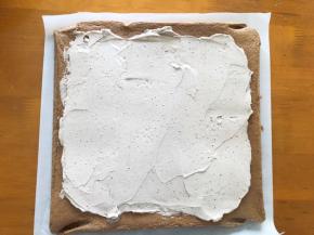 蛋糕出炉撕掉油纸，放在烤网上凉至手温状态，抹上奶油