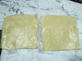 冷藏时间还有15分钟，记得预热烤箱上下190。然后到点取出面团，一分为二，直接保鲜袋里，擀成模具大小两个厚薄均匀的面片。