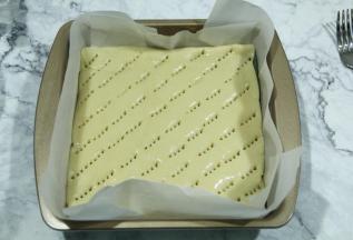 扣上另一片面片，尽量一次扣好，不然挪动很麻烦。提起油纸放入模具中。用叉子扎孔，扎透，防止烤的时候膨胀太过。然后刷一层全蛋液，可以用叉子斜刮出轻轻的纹路。