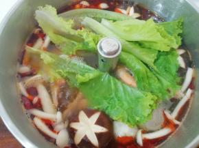 下入鲜虾、莲藕、午餐肉再次煮开，最后下入生菜煮开即可。