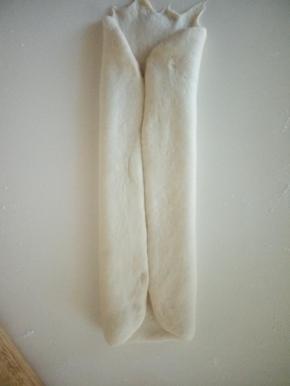 、取一个面团，擀成长方形，两边向中间对折。，卷起。