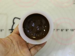 分别将巧克力液倒入模具内，晃动到整个模具四周都粘满了巧克力。