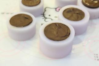 取冷冻好的月饼，融化巧克力液，在月饼底部铺上一层巧克力，再次冰箱冷冻至少4小时以上。