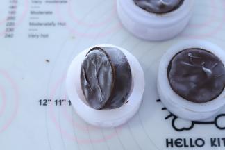 双手掰开月饼模四周，倒扣后往下压出月饼。