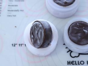 双手掰开月饼模四周，倒扣后往下压出月饼。