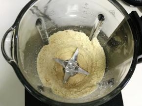 启动破壁机搅打程序，中途可以用刮板刮下粘在壁上的花生粉末，直至打到稍微细腻时，加入花生油。