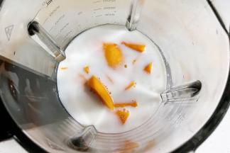 往破壁机中加入芒果和椰奶。