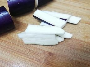 茄子洗干净，把两头切去一块，然后切成适当的段，再切成条