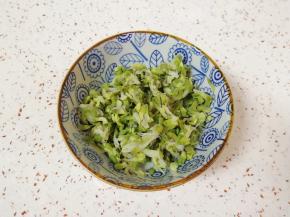 槐花冲洗干净，放在小碗里用开水烫一下，晾凉攥去多余的水分。