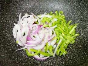 锅底留余油，下入洋葱和青椒丝翻炒均匀。