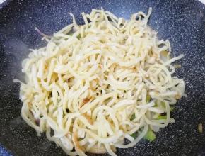 下入饼丝翻炒均匀。