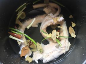 牛蹄筋倒入电饭煲内胆中，继续放入生姜片、香叶、八角、桂皮、2勺料酒；