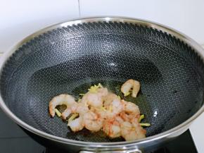 起油锅，倒入腌制好的虾仁煸炒。