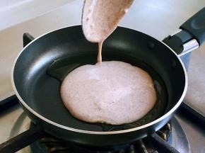 淋入一汤匙半面糊，并转动锅底，使面糊均匀摊薄，一直处于小伙状态。