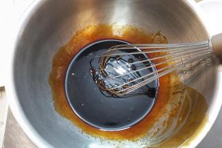 把黑糖糖浆直接倒入打蛋盆内称量好，加入枧水，用蛋抽轻轻搅打均匀，接着再加入花生油，再次搅匀。