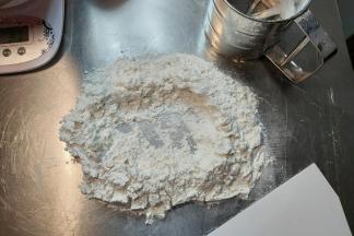 把筛好的月饼粉铺在桌面上，掏个天窗。（面粉预留一部分，根据面团软硬程度进行调整）