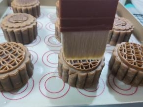 把蛋黄加上牛奶、盐，搅匀，然后取出月饼，放置手温，用毛刷沾上一点点蛋液，用毛尖的五分之一处，轻轻并且快速的在月饼表面刷两下。