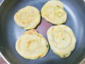 平底锅刷一层食用油，放入葱油饼小火慢煎至两面焦黄色即可。