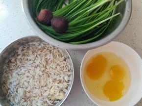 在和面的同时，我们来准备馅料，韭菜摘洗干净，鸡蛋磕入大碗内，虾皮也一定要清洗干净哟。