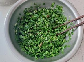 准备个不锈钢小盆，韭菜切碎直接放入小盆内，把晾凉的植物油倒入盆内，搅拌均匀，这样可以锁住韭菜的水分（植物油内的花椒、葱段、姜片记得捞出去哟）。