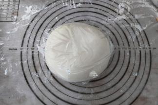 准备好馅料以后，我们的面团基本也和好了，取出面包机内基本光滑的面团，放至案板上揉至光滑，盖上保鲜膜，醒面半小时。