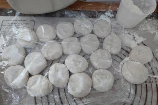 撒上一点面粉，压扁，盖上一张保鲜膜，防止未擀的小剂子表面