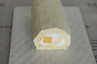 剩余的奶油加糖打发至9成，抹在蛋糕卷表面。