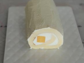剩余的奶油加糖打发至9成，抹在蛋糕卷表面。
