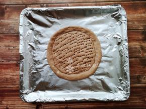 发酵好的面团整形成披萨饼底，用叉子在中间插一些小洞，然后放入烤箱进行二发20-30分钟。然后烤箱175度烤8分钟。再放入蒸锅蒸5分钟。（这一步是为了让饼底在烤制后不变硬）