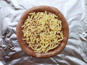 在饼底刷上适量花生油。摆放一层马苏里拉芝士。