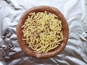 在饼底刷上适量花生油。摆放一层马苏里拉芝士。