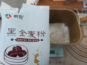 把中筋面粉、黑米面粉、水、酵母、奶粉一起放入面包机的桶内，启动MIX程序，和面20分钟。（没有MIX程序的面包机，直接选择和面的选项即可）