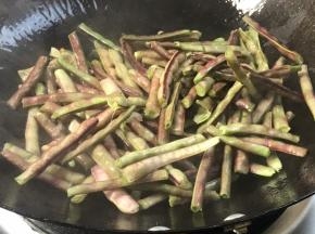 放入豇豆，大火翻炒至变色