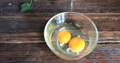 鸡蛋打入碗中，淋入料酒