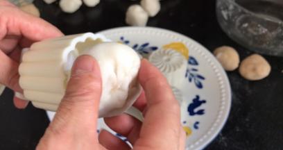 把包好的饼皮月饼皮，收口朝上放入模具内，轻轻按压一下