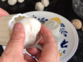 把包好的饼皮月饼皮，收口朝上放入模具内，轻轻按压一下